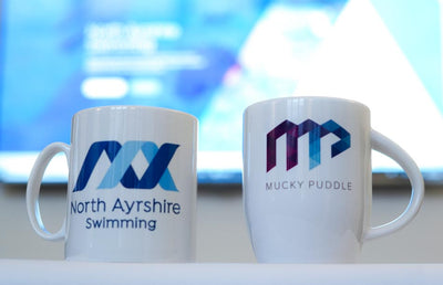 Two mugs - one with the North Ayrshire swimming logo and one with the MP logo.