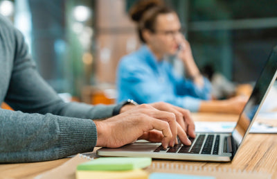 A person typing on an Apple Macbook pro.