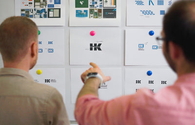 Two MP team members reviewing logos.