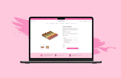 A Macbook Pro with a Mademoiselle Macaron product page and a pink background.