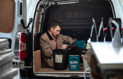 Someone in the back of a Machina coffee van taking stock of deliveries.