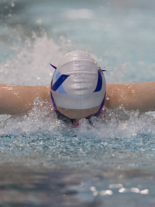 A swimmer wearing a North Ayrshire swimming cap.