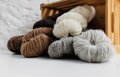 6 threads laid out infront of a wooden box.