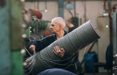 A person carrying a roll of tweed.