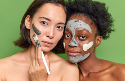 Two people with paint on their face and a paintbrush.