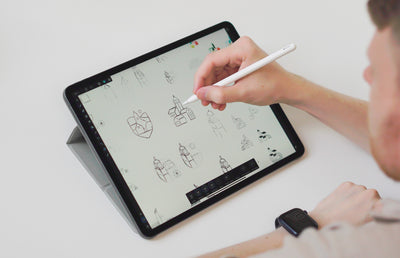 Our brand designer designing the New lanark logo on an iPad.