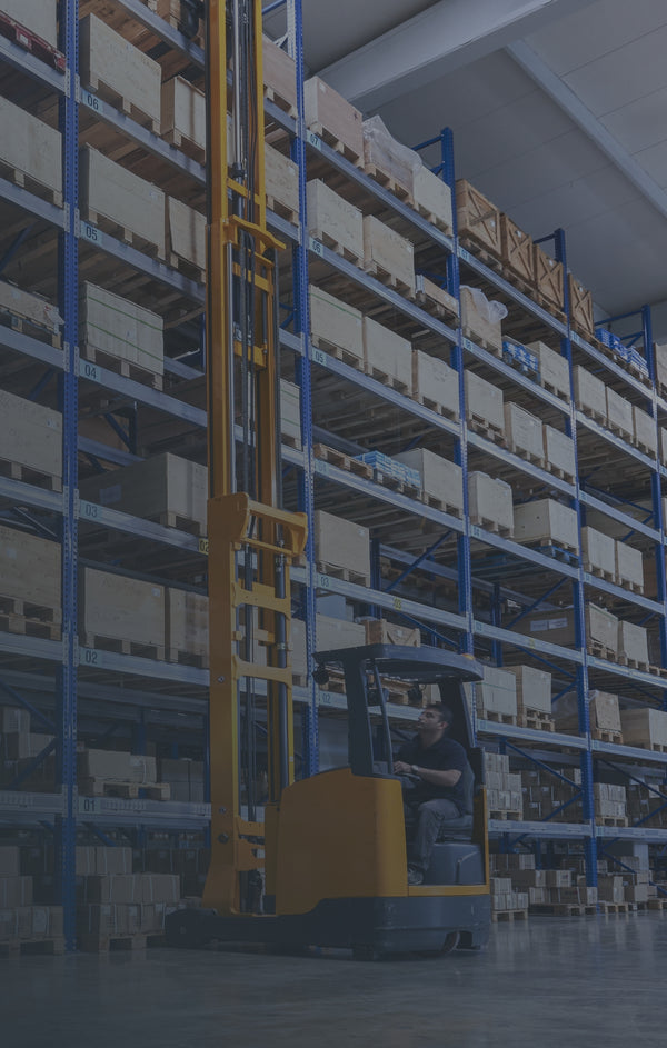 A man operating warehouse machinery.